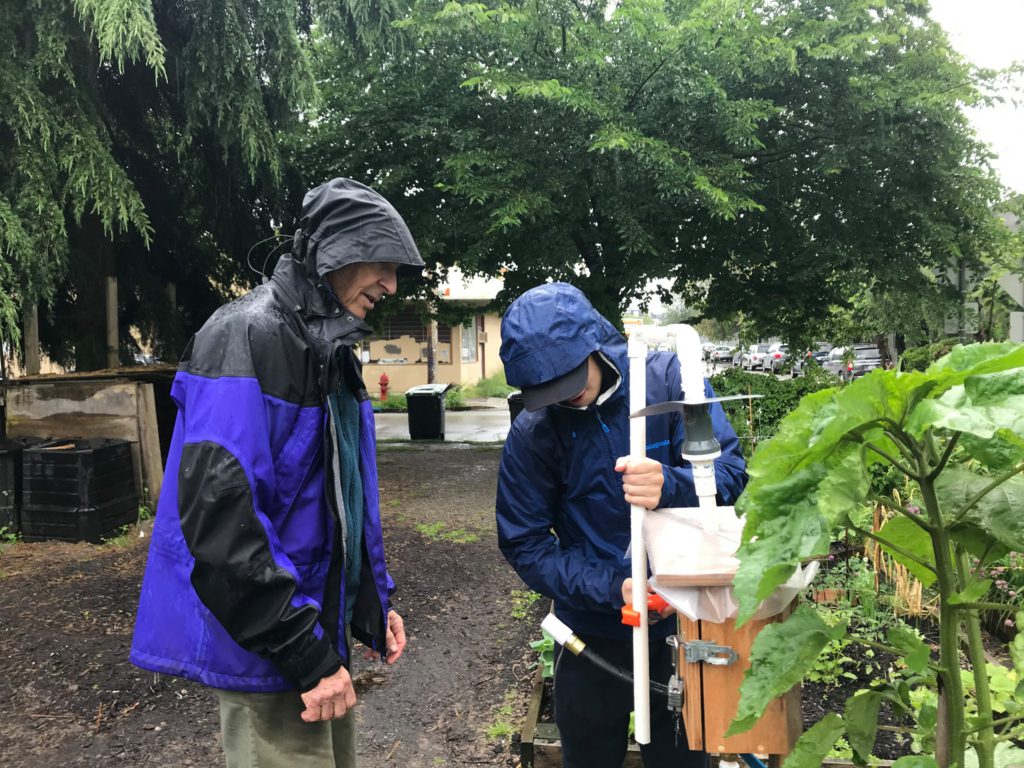 George Shipley and volunteer installing watering system for DIGA.