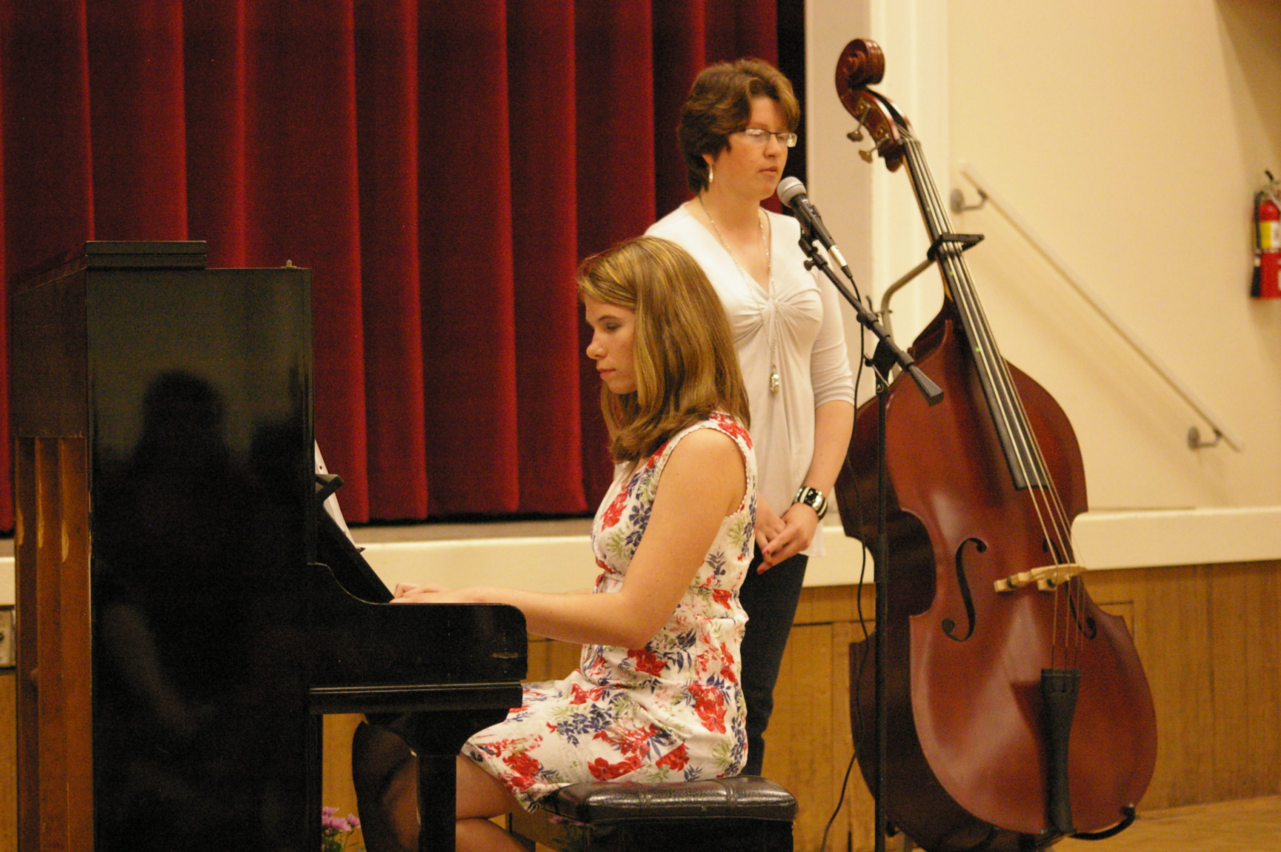 Bailey playing the piano while her sister sings.